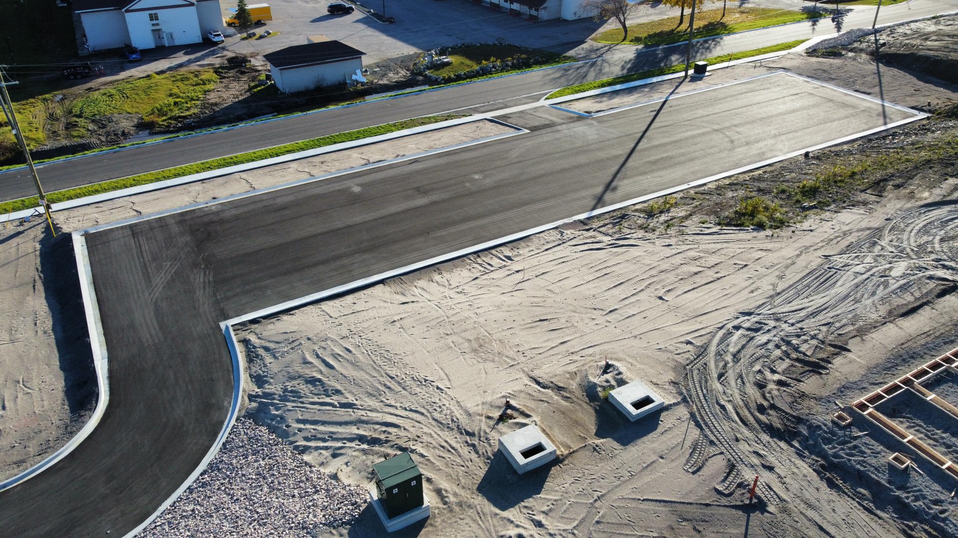 An aerial view of part of the Hillcrest Business Park from October 2025 showing parts of the paved road and parking lot.
