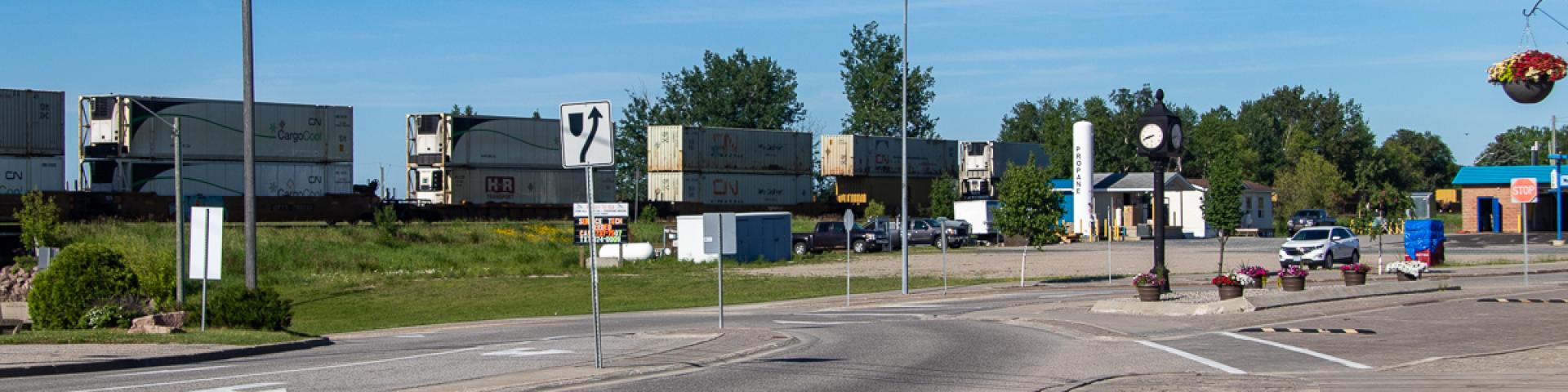 A view of Front Street in Sioux Lookout heading towards the underpass with a train on the tracks